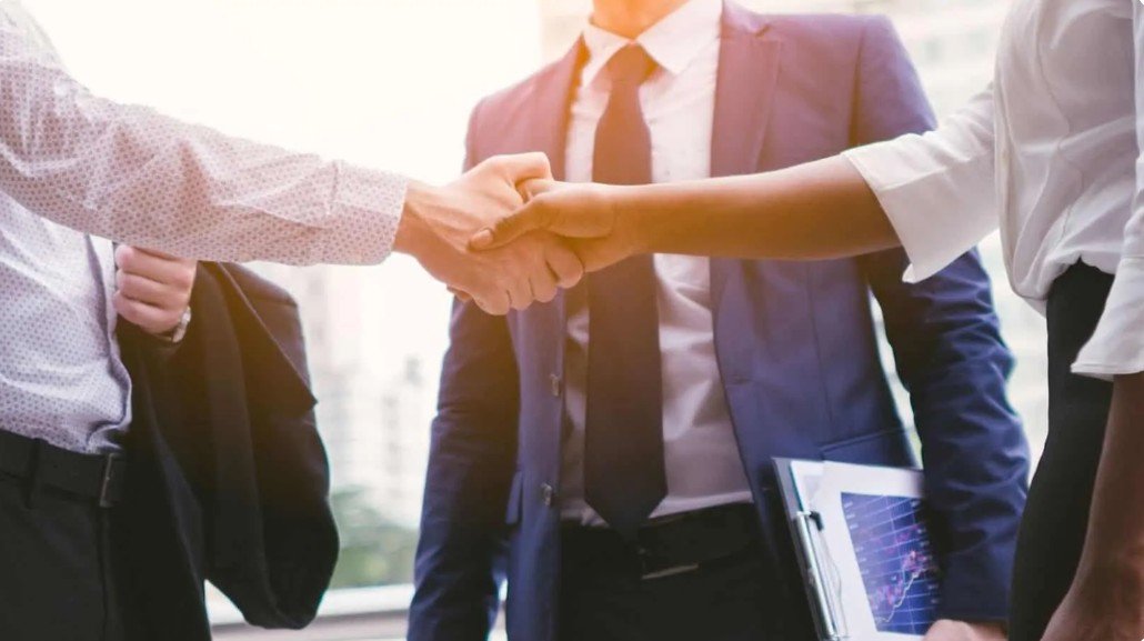 QSP Textile team member shaking hands with a business partner to seal a strategic collaboration.